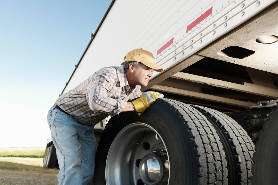 Truck Driver Looking Underneath Truck