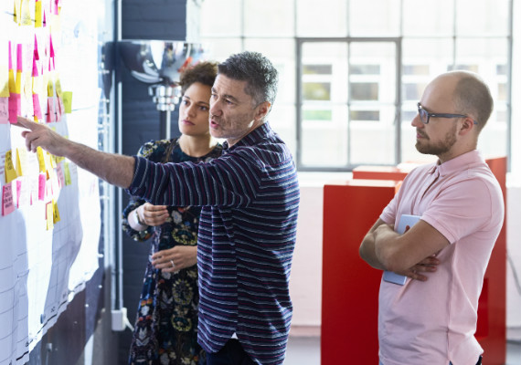 group of coworkers looking at a whiteboard