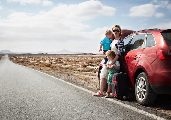 family on side of the road waiting for tow truck
