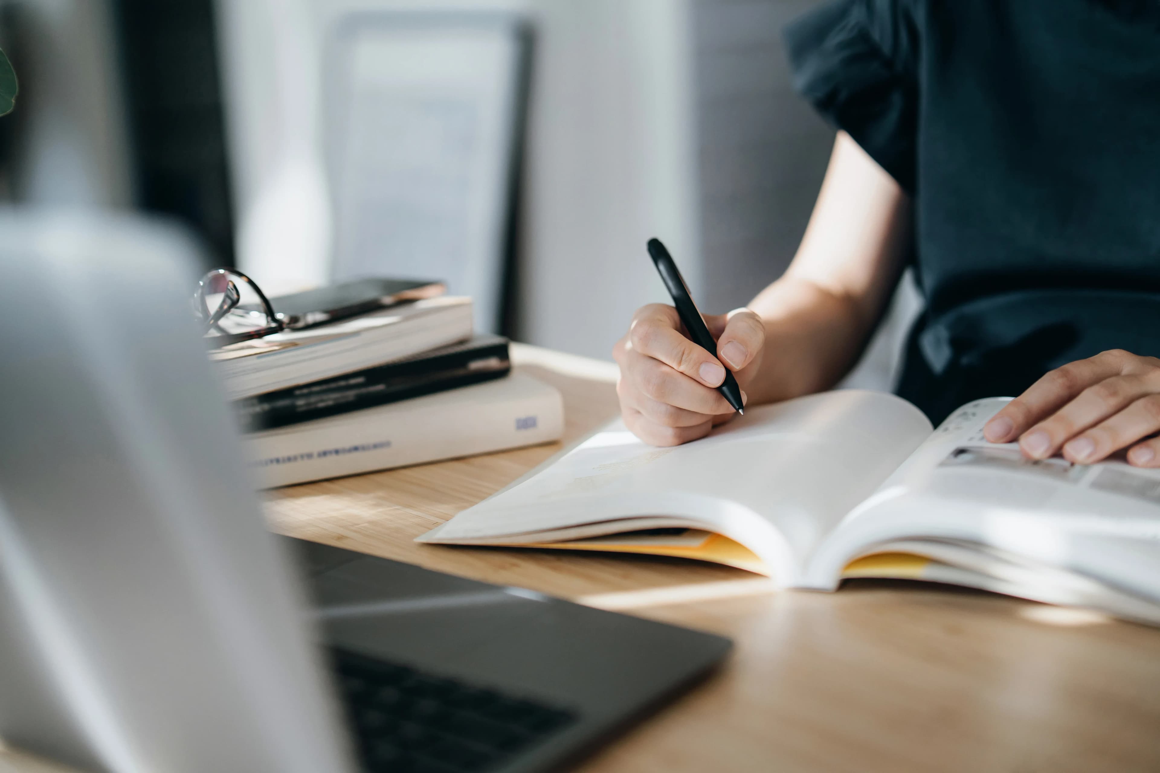 student-writing-beside-laptop