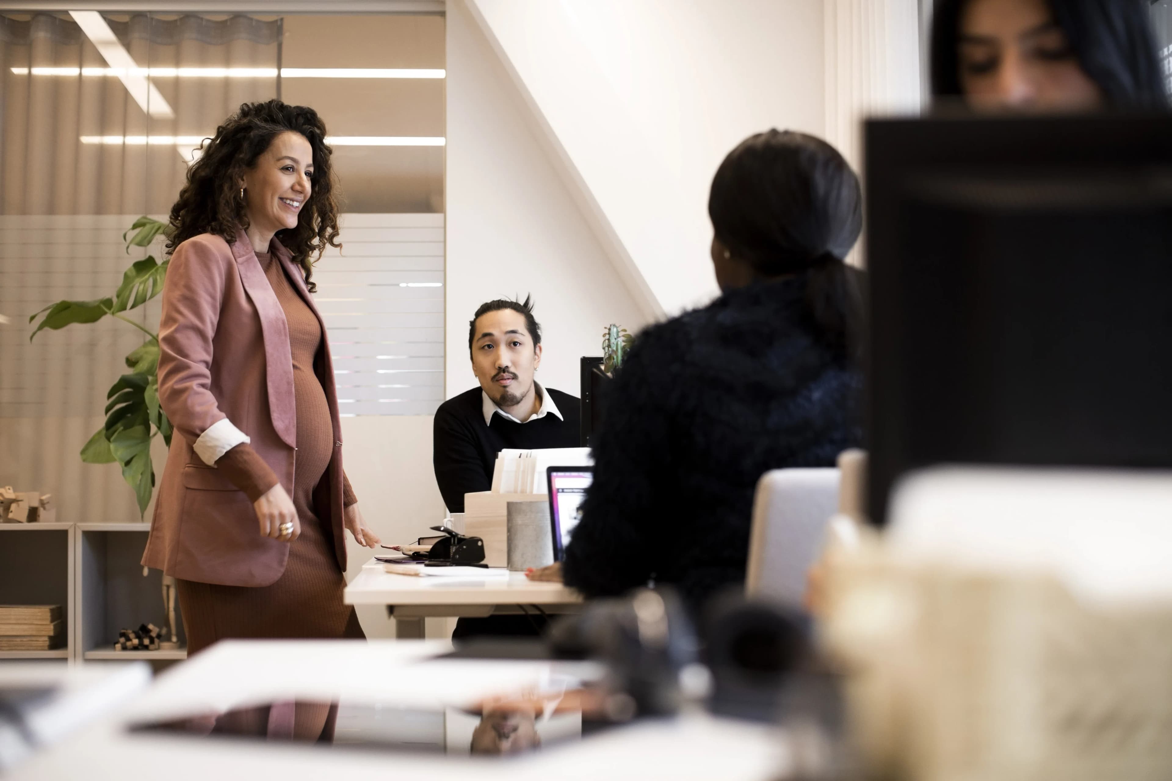colleagues-chatting-around-desk