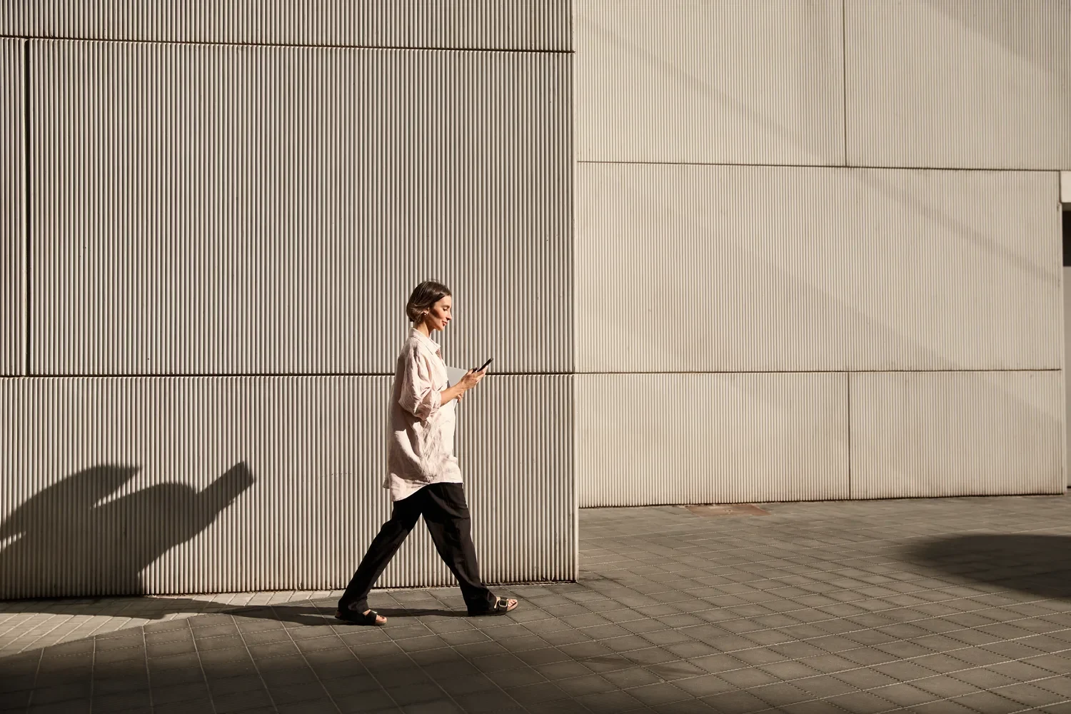 woman-walking-city-sidewalk-phone